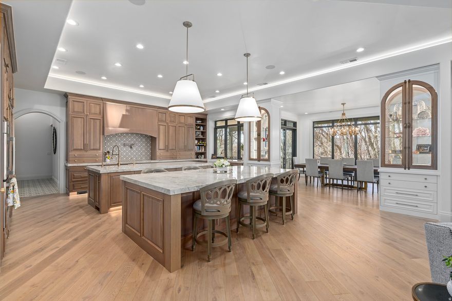 3D Tour available for this home--Click on TOUR button. THE LEGACY AT GREENWOOD CREEK | UNIVERSAL DESIGN MASTERPIECE | Tucked on a quiet cul-de-sac bordering Greenwood Creek, this 10,380 sq. ft. masterpiece (built 2024) blends architectural grandeur with intentional, barrier-free accessibility. SHOWROOM GARAGE: 6-car capacity, epoxy floors, 3 EV outlets, and a 14-foot door for oversized luxury vessels.  CHEF'S KITCHENS: Dual gourmet kitchens featuring Taj Mahal Quartzite, premium paneled appliances, and 10-foot islands.  INCLUSIVE LIVING: True Universal Design with 3-foot wide doorways, curbless showers, and a dedicated ADA-accessible in-law suite.  PRIMARY SANCTUARIES: Two main-level suites with heated floors and a spa-inspired steam shower.  ENTERTAINMENT HUB: 10-foot basement ceilings, professional theater, indoor sports court, and exercise room.   ALFRESCO LIVING: Heated covered deck with pizza oven and outdoor kitchen overlooking the creek.  ELITE STORAGE: Massive dedicated storage gallery plus main level 13-foot hidden Christmas Tree Closet.  INFRASTRUCTURE: Whole-home filtration, Cat 6 wiring, and 3 HVAC systems, deck ceiling heaters, heated bathroom floors, radiant heat barrier on roof.  Minutes from Silicon Slopes and shopping; just 30 minutes to world-class ski resorts.  Detailed upgrade list available upon request.  OWNER/AGENT.