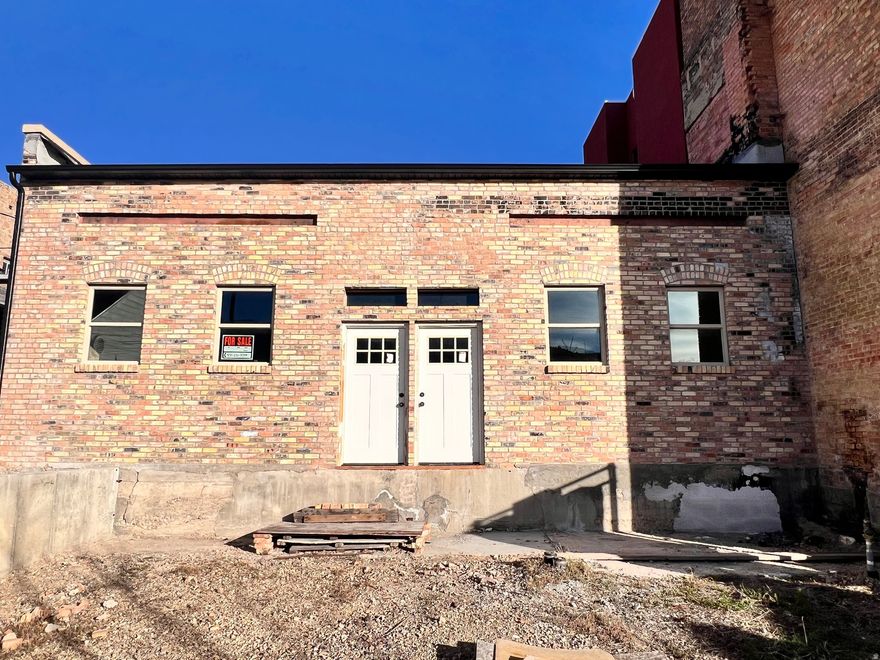 Bring your vision to life in the heart of Helper's Historic Main Street! This 1900's building has endless potential. The West facade has been beautifully rebuilt using reclaimed brick, new windows and new rain gutters, while the interior has been stripped to stunning exposed brick walls, ready for your custom touch. The building currently has 3 Main St entrances, 2 doors leading to the main level and 1 door that takes you to the full unfinished basement. The large rear parking area borders 100 West with 3 more entrance options, offering flexible access points, 2 on the main level and one being a new ADA compliant entrance to the basement. A new electrical panel is in place (needs connections) and a rear grease pit adds restaurant potential. Whether you dream of a retail storefront, cafe', office, or live/work space, this property offers a rare chance to create something special in Helper's thriving downtown.  Square footage figures are provided as a courtesy estimate only and were obtained from Carbon County Recorder.  Buyer is advised to obtain an independent measurement. Buyer to verify all listing information independantly.