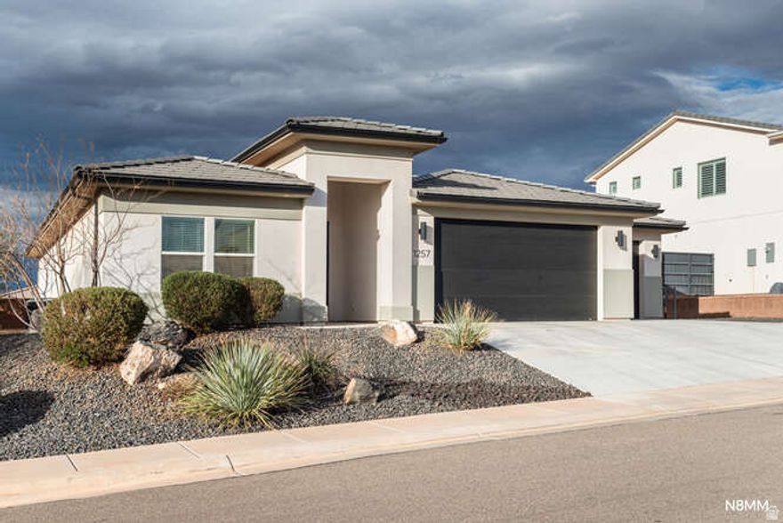 Just listed--and already turning heads. This nearly new home blends modern design, smart layout, and one feature buyers are constantly searching for but rarely find a 4 car garage in this price point. Whether you have toys, tools, hobbies, or just love extra space, this is a game-changer. Inside, the open great room floor plan creates a bright, welcoming space perfect for entertaining or everyday living. The primary suite is tucked privately from the other 2 bedrooms, offering privacy and comfort for everyone. The exterior delivers instant curb appeal with sleek modern elevations and a desert-scape front yard. for easy maintenance. The backyard is a blank canvas--ready for a pool, outdoor kitchen, play area, or your dream backyard retreat.  Located in Warner Gateway with its own neighborhood community pool. A brief 2-3 minute walk to Crimson Cliffs schools, and powered by Dixie Power, known for its lowest electric costs in Utah. This home is as practical as it is impressive.