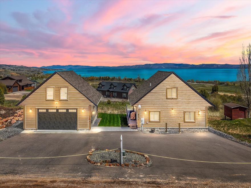 Bear Lake Retreat on Rare Double Lot - Fully Furnished!! Experience the ultimate getaway in this meticulously crafted 2019-built home, perfectly situated on a quiet cul-de-sac within a secure gated community. This property offers breathtaking lake views and is just five minutes from Garden City, the marina and beaches. The home has been lightly used and feels brand new. Best of all, both livings spaces come fully furnished, allowing you to move in and start enjoying the lake life immediately. A highlight for outdoor enthusiasts is the massive garage with an asphault driveway, providing ample, secure storage for boats and UTVs. Above the garage sits a private, 600 sq. ft. guest suite. This fully self-contained living space includes a kitchen, bedroom, full bath, and a private living area that opens onto a large back deck?perfect for guests or a separate rental opportunity. The exterior is rounded out by a fully landscaped yard with an automated sprinkler system, ensuring a lush setting with minimal effort.  Square footage figures are provided as a courtesy estimate only and were obtained from County records.  Buyer is advised to obtain an independent measurement.