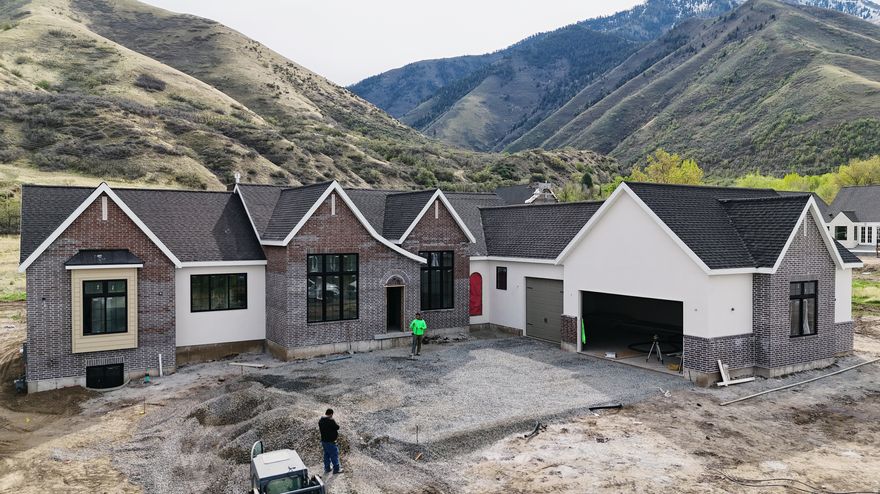 Introducing our newest floor plan designed specifically for this lot: The Bridgette, featuring timeless Tudor styling. With over 6100 Sq. Ft. total and 3,100 square feet on the main floor, this home offers the convenience of single-level living, including a luxurious primary suite and expansive gathering spaces ideal for entertaining. The finished basement includes three additional bedrooms, a full bath, and a large family room, with the option to create a one-bedroom mother-in-law apartment or ADU with a separate entrance. A west-facing orientation provides stunning afternoon light and mountain views, best enjoyed from the covered deck. The massive backyard offers endless possibilities for outdoor living, recreation, or future customization. Throughout the home, luxurious and thoughtfully selected finishes elevate both style and comfort. Completion is scheduled for early May.Call today to arrange a private showing.