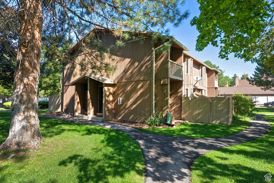 Amazing row-end townhome in a convenient east side, quiet and well-kept, gated Hidden Village community. This home blends comfort and charm with a cozy living room featuring a fireplace and laminate floors, fresh paint, and white bead board accents on the main level. The bright breakfast nook with a bay window opens to a spacious enclosed patio, perfect for sunny mornings or evening chats. Upstairs you'll find two bedrooms, including a primary with two closets and a private balcony with mountain views. The basement offers a separate living area with its own living room, bedroom, a 3/4 bath, and a laundry room-providing flexible space for guests, an in-law setup, or rental potential. All appliances included! One covered parking space and one uncovered parking space come with the unit, and the owner may rent a small storage unit, extra parking, or RV parking on site. Tucked away in Hidden Village, the grounds feature large ferns and pine trees, quiet walkways, and private patios. Community amenities include a pool and picnic areas and is gated for resort-style living in a peaceful neighborhood.