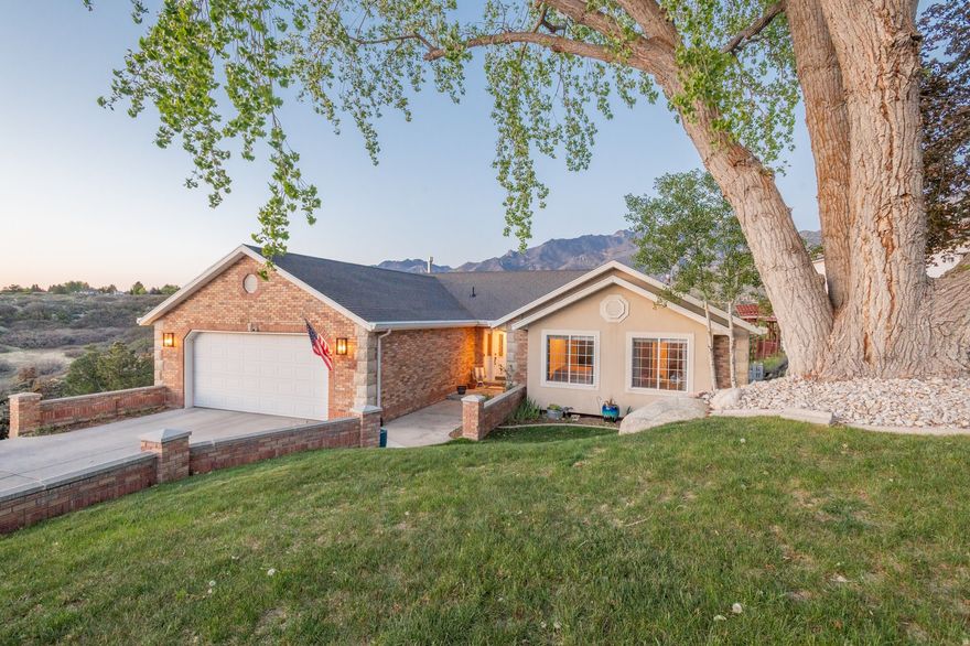 Rare opportunity on the Sandy East Bench in Dimple Dell Ranchettes with truly exceptional, unobstructed mountain views. This 5-bedroom, 3.5-bath walkout home has been thoughtfully renovated, perfectly positioning it to capture panoramic Wasatch views and stunning Oquirrh Mountain sunsets. The home benefits from a unique elevated setting, positioned above neighboring properties to preserve view corridors and maintain privacy. Located just steps from Dimple Dell Park, the property offers immediate proximity to hundreds of acres of protected open space and trail systems. The approximately $250,000 interior transformation features a designer-curated palette with new hardwood flooring, a gourmet kitchen with quartzite natural stone countertops, and new appliances. The living room showcases vaulted ceilings with custom wood beams and a double-sided glass fireplace with quartzite surround as a central focal point. The walkout lower level has been completely remodeled with new LVP flooring and a custom bar with beverage refrigerator, sink, and cabinetry. Designed as true above-grade style living space, this level offers natural light and direct access to the patio and hot tub. Outdoor living is a standout feature with $100,000 invested in a wraparound Trex deck and patio designed for seamless indoor-outdoor entertaining. Additional features include a renovated laundry room, epoxy garage flooring, Tesla charger, and HOA amenities. Move-in ready and just minutes from Little and Big Cottonwood Canyons.