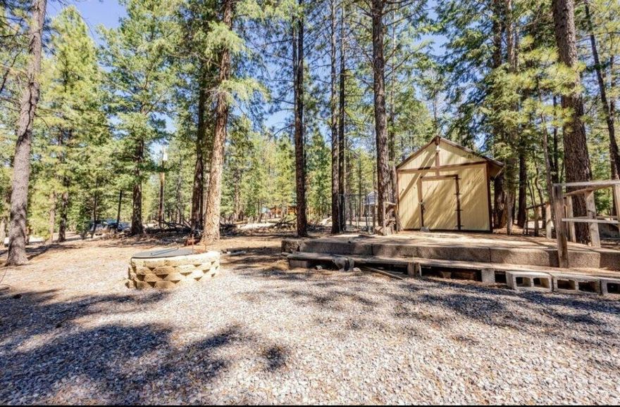 This beautiful lot located at Swains Creek Pines is a must see you don't want to miss out on! This improved lot is level and ready to build and enjoy. Power, water and septic are installed to accommodate a cabin and features a gravel driveway, a fully furnished bunk house including a refrigerator, queen murphy bed, ceiling fan and power. The evenings can be spent sitting on the existing deck and keeping warm next to the fire pit. Enjoy natures beautiful ponderosa pines and it's a short walk to the stocked community fishing pond. Access is year round. The community offers a landing strip, park and a gazebo. You may park your RV on the property up to 12 months with an active building permit. Seller will consider all reasonable offers.