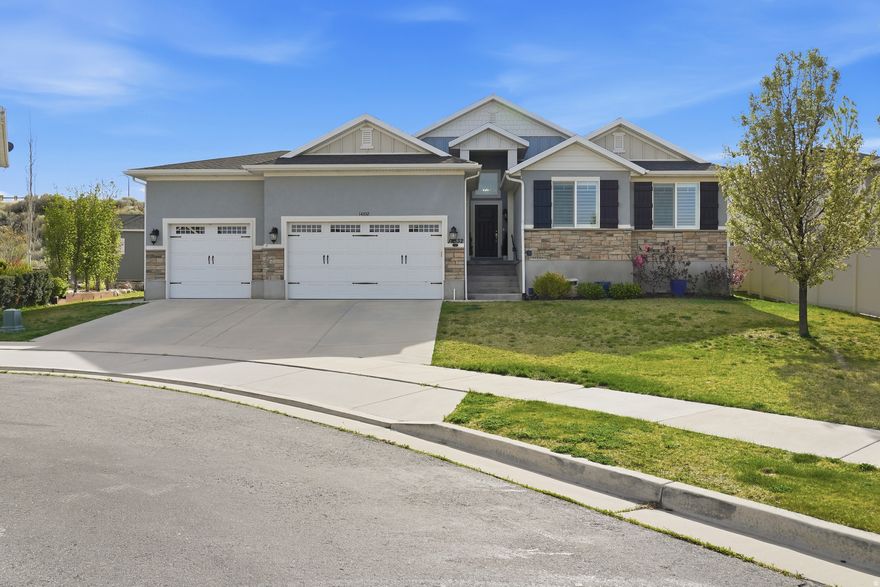 Welcome to this stunning 3,728 sq ft rambler tucked inside a quiet cul-de-sac, offering 7 bedrooms, 3 full bathrooms, one 3/4 bath, and one half bath, along with a spacious 3-car garage and thoughtfully designed living spaces throughout. This beautifully crafted home features hand-scraped wood floors, plantation shutters, and custom millwork, creating a warm and timeless feel from the moment you walk in. The heart of the home is a chef's kitchen designed for both everyday living and entertaining, complete with a 60" Frigidaire Sub-Zero refrigerator/freezer combo, three pantries, farm sink, 6-burner gas cooktop, and a large kitchen island with an integrated table that comfortably seats six. The kitchen light switches can also be connected to Alexa for convenient smart home control, adding modern functionality to this beautifully designed space. The main floor also features a striking white stone fireplace with black marble inlay, adding elegance and character to the living area. The primary suite offers vaulted ceilings and a beautifully designed bathroom with a get-ready station, custom tile surrounds, and dual shower heads, creating a private retreat. Additional features include soft water, two furnaces, and Quantum fiber internet, providing comfort and modern convenience throughout the home. The full basement is designed as a private mother-in-law apartment (attached ADU) with its own separate walk-out entrance and private patio for entertaining, full kitchen with island, breakfast nook, family room, and 3 bedrooms and 2 full bathrooms. One of the bedrooms includes a private ensuite, and the unit also features two large pantries and its own dedicated laundry room, making it ideal for multi-generational living or rental potential. Sellers are generously including both sets of washers and dryers, both refrigerators, hot tub, patio furniture, BBQ grill, Blackstone, water softener, gardening pots, large wall clock, and family room couches, end tables, and coffee table, adding exceptional value and convenience for the new owners. This home offers space, flexibility, and thoughtful design in a peaceful cul-de-sac setting - perfect for those seeking comfort, functionality, and the added benefit of a fully equipped attached ADU.