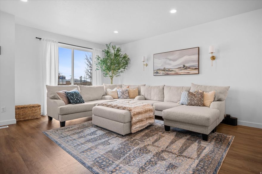 This extraordinary Townhome is for you! Aside from it's brilliant floor plan with lots of natural light, custom cabinetry, and modern features; the owners have added their personal touches like an epoxy garage floor, built-in shelving, a tankless water heater, an EV 220 outlet, quartz countertops, LVP flooring, and custom curated finishes right down to the gold hardware! The location is of KEY IMPORTANCE; just minutes of walking distance to Layton Park and amphitheater, grocery and retail shopping, several eateries, gas stations, and easily under 3 minutes to I-15. The HOA covers exterior maintenance, green space, picnic tables, and a TOT-LOT playground for the little ones. Affordable and smart living ~You must see this gem for yourself!