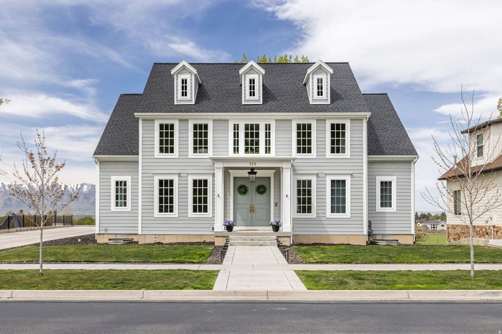 Colonial house with a shingled roof and a front yard