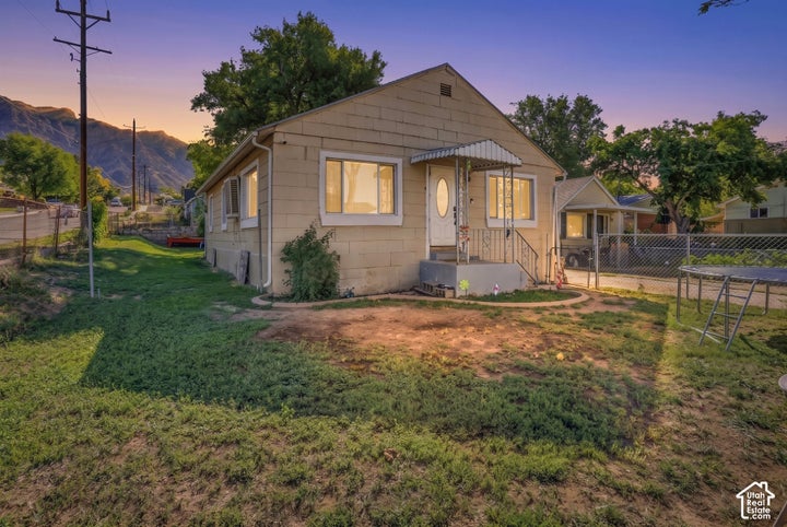 Single-story residence with a covered porch entry, multiple windows, and a paved driveway