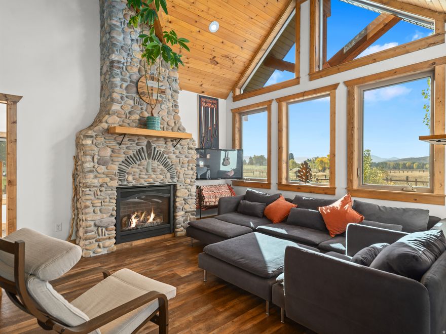Situated on nearly 2.32 acres, this inviting craftsman-style home combines generous open space with an exceptionally convenient location-only minutes from Powder Mountain and about 20 minutes from freeway access for an easy commute. There's ample room for pasture, a future barn or loafing shed, and simple trailer maneuvering, making it a true horse property that balances comfort with outdoor adventure. Inside, a vaulted great room greets you with large windows showcasing sweeping mountain and meadow vistas. A river-rock gas fireplace with timber-beam accents brings cozy rustic character, while the open kitchen highlights a butcher-block island, fresh white cabinets, and bold black pendant lights. From the dining area, French doors lead outside, seamlessly extending entertaining into the crisp mountain air. On the upper level, the primary bedroom offers private access to a covered deck-an ideal spot for morning coffee or sunset relaxation. Outdoors, a fenced lawn and wood fire pit provide the perfect setting for evenings under the stars. With abundant space for gardens, animals, and future outbuildings, this property offers wide-open living from alpine mornings to expansive, starlit nights. All property information, boundaries, and documents to be verified by the buyer.
