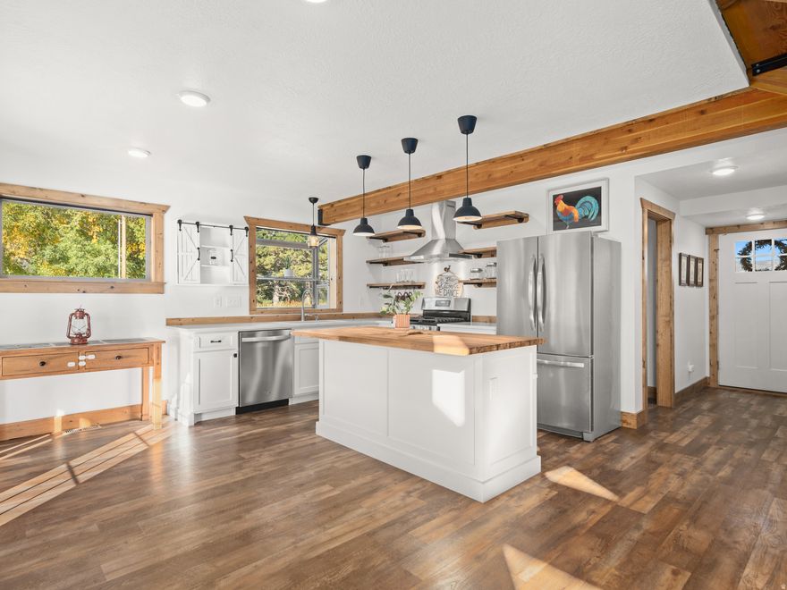 Situated on nearly 2.32 acres, this inviting craftsman-style home combines generous open space with an exceptionally convenient location-only minutes from Powder Mountain and about 20 minutes from freeway access for an easy commute. There's ample room for pasture, a future barn or loafing shed, and simple trailer maneuvering, making it a true horse property that balances comfort with outdoor adventure. Inside, a vaulted great room greets you with large windows showcasing sweeping mountain and meadow vistas. A river-rock gas fireplace with timber-beam accents brings cozy rustic character, while the open kitchen highlights a butcher-block island, fresh white cabinets, and bold black pendant lights. From the dining area, French doors lead outside, seamlessly extending entertaining into the crisp mountain air. On the upper level, the primary bedroom offers private access to a covered deck-an ideal spot for morning coffee or sunset relaxation. Outdoors, a fenced lawn and wood fire pit provide the perfect setting for evenings under the stars. With abundant space for gardens, animals, and future outbuildings, this property offers wide-open living from alpine mornings to expansive, starlit nights. All property information, boundaries, and documents to be verified by the buyer.