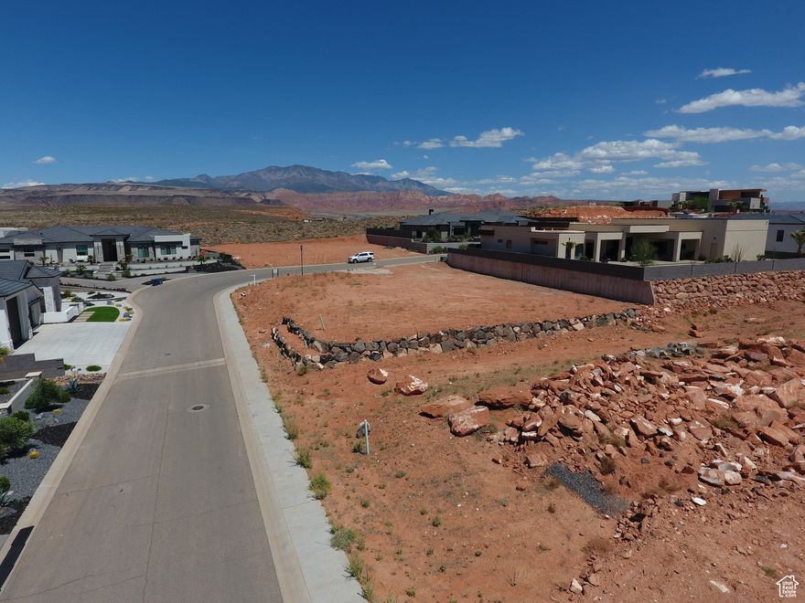 Seize the opportunity to build your dream home in the exclusive, gated community of Westgate Hills!  This pad-ready lot is nestled among luxury estates and features a professionally constructed rock retaining wall-saving you time and expense.  Enjoy breathtaking mountain views in the scenic Green Springs area, just minutes from world-class golf, fine dining, and shopping.  Whether you bring your own architectural vision or select from the builder's curated collection of sophisticated designs, this is a rare chance to secure your place in one of Southern Utah's most sought-after communities!