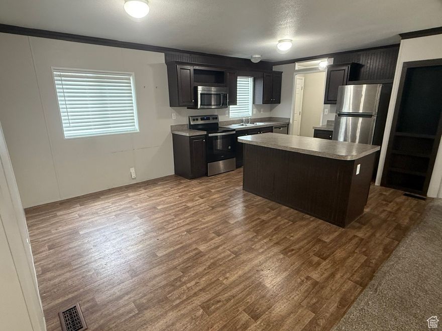 Welcome home to easy, single-level living in this bright and well-kept 3 bedroom, 2 bathroom manufactured home. An open-concept living room flows into a spacious kitchen with abundant cabinet space, a breakfast bar, and a dining nook-great for everyday meals or hosting friends. The split-bedroom layout gives the master bedroom added privacy, featuring an ensuite bath and walk-in closet. Two additional bedrooms and a full bath offer flexible space for family, guests, a home office, or hobbies. A dedicated laundry room adds everyday convenience. Outside, enjoy a covered porch, low-maintenance yard, and 3-car covered parking.