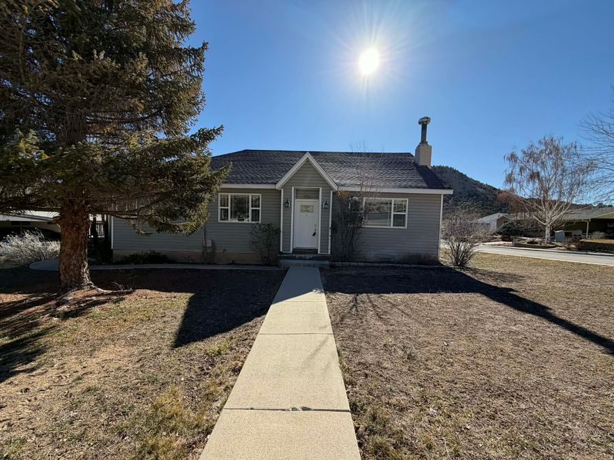 A little slice of heaven in Helper, Utah! This beautiful home offers a spacious primary suite and a well-designed floor plan with room to spread out. You'll love all the clever nooks and crannies that provide extra storage throughout the home.  Step outside to an amazing deck perfect for backyard barbecues and entertaining. Covered parking is a breeze with both a garage and a carport. Recent upgrades include a new roof and new windows, adding value and peace of mind. As a bonus, you'll enjoy easy access to a paved walking and running trail just steps away.  Square footage figures are provided as a courtesy estimate only and were obtained from Carbon County .  Buyer is advised to obtain an independent measurement.