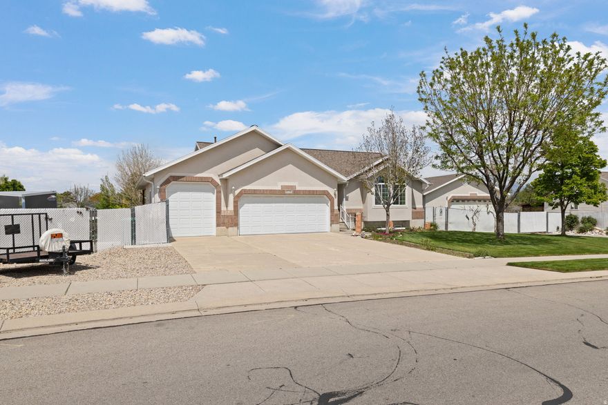 Searching for a home with the ultimate garage and workshop setup? Your search ends here. This impressive 30x40x14 detached shop features an oversized 12x18 garage door and space for at least four vehicles. Designed with functionality in mind, the shop includes both a wood stove and gas heater, full electrical and cable wiring, two 50-amp outlets, an enclosed airline system with air compressor, a private half bath, and easy access for larger vehicles and equipment. The home itself has been just as meticulously maintained. Owned by only one owner since it was built, pride of ownership is evident throughout. Inside, you'll find a full walk-out daylight basement featuring a fully self-sufficient apartment with separate laundry; ideal for multigenerational living, guests, or rental income potential to help offset your mortgage. The main level offers tall vaulted ceilings, abundant natural light, and a thoughtfully designed floor plan that combines comfort and functionality. Step outside to enjoy the beautifully manicured yard and custom water feature from the covered deck or included hot tub. Gardening enthusiasts will appreciate the dedicated garden space and greenhouse. Additional features include an attached 3-car garage with an extra-tall third bay and a 50-foot RV parking pad located on the west side of the home. Whether you're looking for comfort, workspace, storage, or income potential, this property offers exceptional versatility with no detail overlooked. Located just minutes from Jordan Landing for shopping and dining and with easy access to Bangerter highway, you also won't find yourself sacrificing location for all this!  Square footage figures are provided as a courtesy estimate only.  Buyer is advised to verify all information contained in listing.