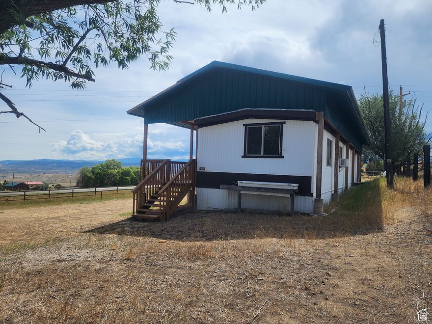 Escape to your own piece of paradise! This charming mobile home is the perfect getaway, whether you're looking for a vacation spot or a weekend retreat.   This 2-bedroom, 1-bathroom home is in a prime location, just minutes from downtown Manila. The home features a very large, solidly built deck, perfect for taking in the stunning views of Flaming Gorge and the valley. An aluminum roof has been beautifully constructed over the entire home and deck, providing shade and protection from the elements. This home is perfect for those who love the outdoors; Enjoy boating, fishing, and other recreational activities of your choice with the Flaming Gorge Reservoir just a short distance away. The property boasts a large .60 acre lot, perfect for parking your RV, boat, or other recreational vehicles, and a large storage shed, providing additional space for all your gear. The home has been well-maintained and features newer AC units, updated water heater, and a regularly serviced septic system. Don't miss out on this opportunity to own a piece of paradise near Flaming Gorge! Square footage figures are provided as a courtesy estimate only. Although information provided is deemed to be accurate, buyer is advised to obtain an independent measurement, and verify all.