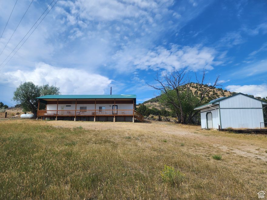 Escape to your own piece of paradise! This charming mobile home is the perfect getaway, whether you're looking for a vacation spot or a weekend retreat.   This 2-bedroom, 1-bathroom home is in a prime location, just minutes from downtown Manila. The home features a very large, solidly built deck, perfect for taking in the stunning views of Flaming Gorge and the valley. An aluminum roof has been beautifully constructed over the entire home and deck, providing shade and protection from the elements. This home is perfect for those who love the outdoors; Enjoy boating, fishing, and other recreational activities of your choice with the Flaming Gorge Reservoir just a short distance away. The property boasts a large .60 acre lot, perfect for parking your RV, boat, or other recreational vehicles, and a large storage shed, providing additional space for all your gear. The home has been well-maintained and features newer AC units, updated water heater, and a regularly serviced septic system. Don't miss out on this opportunity to own a piece of paradise near Flaming Gorge! Square footage figures are provided as a courtesy estimate only. Although information provided is deemed to be accurate, buyer is advised to obtain an independent measurement, and verify all.