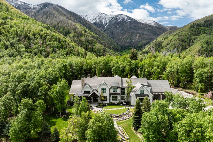 Incredible 14,000 sf home located on 2.6 acres in Woodland Hills. Complete privacy, spectacular views, and the finest craftsmanship. Built by McEwan Construction, this property is the perfect mix of elegance and fun. Your family will love the amenities: a 46'x36' basketball court that can also be used for pickleball, a rock climbing will with an automatic belay, a resistance pool, hot tub, two exercise rooms, a game room, a huge theater room, and a children's playhouse. Some of the most notable features of the home are the reclaimed wood elements. There are large wood beams that were from old barns in Ohio, shiplap from a ranch house in Texas, and the wood floors on the main level are a rustic reclaimed hickory and they look so good. The heart of the home is the chef's kitchen and the two-story vaulted family room that boasts a wall of windows and a gorgeous stone fireplace. The kitchen is well equipped with Wolf and SubZero appliances, plenty of countertop space, and a wonderful butler's pantry. Between the island, dining room, and family room there is seating for everyone, and when you combine that with all of the fun elements this one of the best entertaining homes around. Of course, the primary suite is spectacular, the office is perfect for working from home, the living room is ideal for a piano, and the bedrooms all have their own private bathrooms. Plus, there is a 4 car garage and the driveway has radiant heat. It is one of the most spectacular homes and locations anywhere along the Wasatch Front.