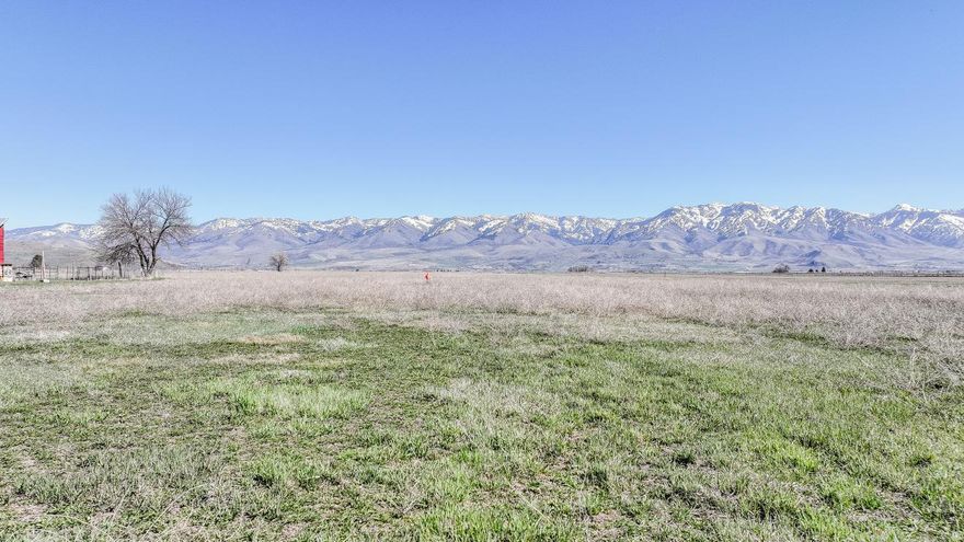 Picturesque flat lot in rural Fairview area with mountain views all around. With easy access to town and close to Utah.  Large parcel to build on and still have plenty of room for animals.  PERC test and survey have been done and will be provided.  Buyer will need to drill a well.  8 water shares of Cub River Irrigation come with the acreage and is on a private pressurized line. Address is approximately 5300 S State Street, Preston-.  ID land map is available on tour tab function.