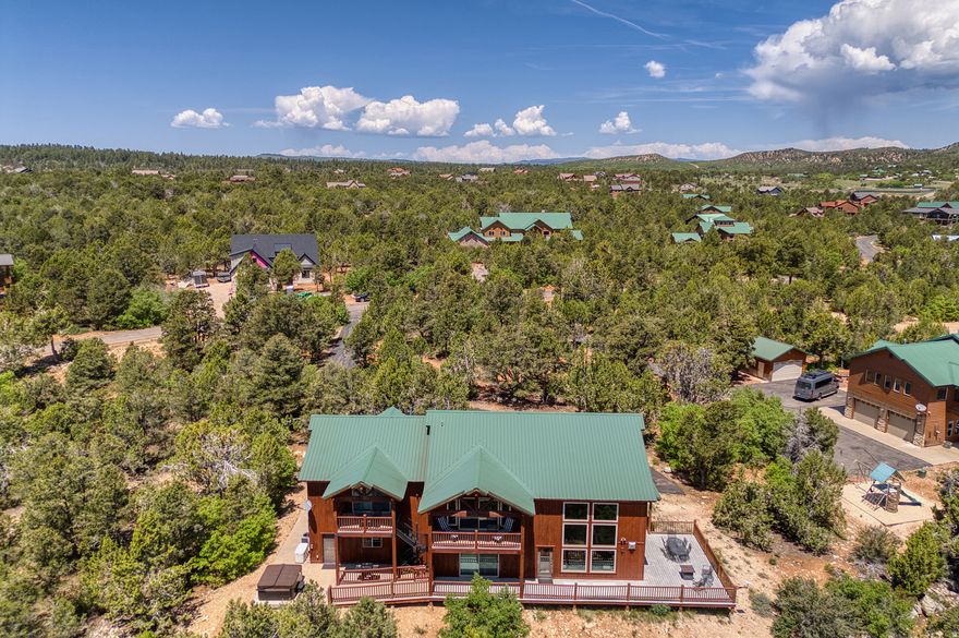 Approved nightly rental in East Zion, now even better with a full suite of upgrades. This fully furnished, turnkey mountain home sits on 1.26 acres at the end of a quiet cul-de-sac in the gated Zion Ridge community. With 4,003 square feet, five bedrooms, and five bathrooms-including two spacious master suites-there's plenty of room for family, guests, or rental groups. The home has been thoughtfully updated to create an even more comfortable and enjoyable experience. A brand-new hot tub now sits on the back patio, paired with new outdoor furniture for relaxing evenings under the stars. Inside, you'll find all-new smart TVs throughout, fresh linens and towels, and a beautiful new dining table perfect for gathering. New fiber optic internet is lightning fast.  The garage has been fully converted into a dedicated game room with a complete arcade setup and new epoxy floors. Starlink high-speed internet has been added for reliable streaming and remote work, and fiber optic service is expected in the neighborhood soon.  The home features open-concept living with a large kitchen, stainless steel appliances, granite throughout, and an oversized fridge and freezer. Both primary suites open to private decks with sweeping views, and a second upstairs living area provides extra space for entertaining or larger groups. Additional value includes a new HVAC system, lifetime warranty windows, and a whole-home backup generator.  Just 8.5 miles to Zion's East Entrance, this is an ideal basecamp for adventure or a peaceful retreat. Close to Zion Ponderosa Ranch, the Applecross mountain bike trails about a mile down the road, and easy access to Kanab, Lake Powell, and the North Rim of the Grand Canyon.  Whether you're looking for a personal getaway or a strong investment property, this East Zion nightly rental is ready to impress.