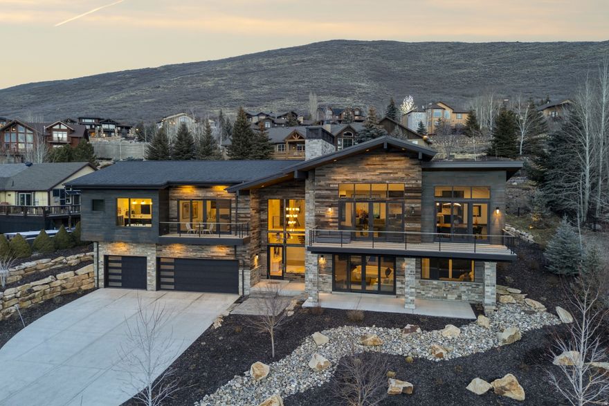 Where design meets lifestyle, this mountain contemporary Deer Mountain residence offers beautiful reservoir views and thoughtfully curated spaces for gathering. The upper-level great room is positioned to capture the scenery, featuring expansive windows and an open-concept kitchen, dining, and living area ideal for entertaining and everyday comfort. Designed to comfortably host family and guests alike, the home offers 4 bedrooms and 3.5 bathrooms, including a custom-built bunk room and adjacent game room that create a dedicated space for recreation and relaxation. Outdoor living is equally inviting, with a heated paver patio, sunken hot tub, an in-ground hidden gas fire pit, and a built-in BBQ designed for year-round enjoyment. Smart home integration includes app-controlled Lutron lighting, Bond motorized blinds, and a comprehensive security system with advanced camera coverage for effortless control and peace of mind. Located in the welcoming neighborhood of Deer Mountain known for community events and access to hiking and biking trails, the property offers both privacy and connection just minutes from Deer Valley's East Village and Park City amenities.