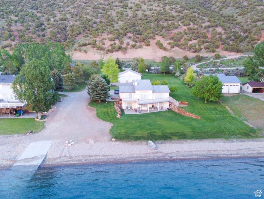 Superior secluded lot with private beach with mountain and lake views. Private concrete launching ramp shared with North neighbor. Two additional large bedrooms in the basement (no windows) each with a sink vanity. Detached garage with guest house - 638 sq. ft., including a furnace, water heater, semi-kitchen, family room, 1 bedroom and 3/4 bathroom. A gas house/utility shed (132 sq ft) with 600 gal aluminum fuel tank. The attached garage includes a large personal safe. Personal Artesian well 300+ft deep, drinking quality water to be used for sprinkling system and back-up culinary. The dwellings can sleep up to 20 people. Square footage figures are provided as a courtesy estimate only. Buyer is advised to obtain an independent measurement. Owner related to inactive sales agent. Property includes two lots.