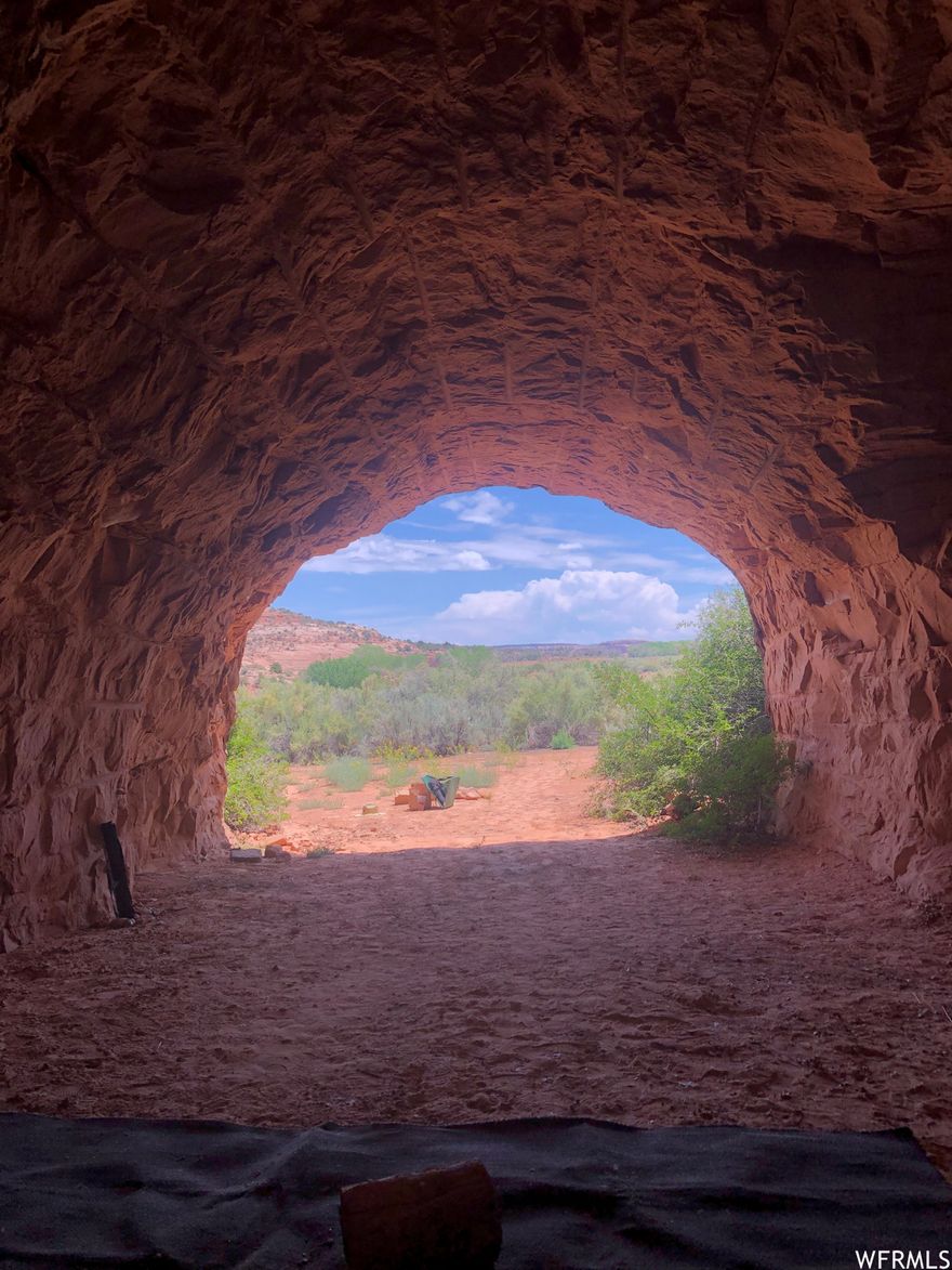 HIGH DESERT RED ROCK CAVES. 54.61 acres of majestic high desert slick rock, juniper, and sage along Hatch Wash, the major drainage from the Abajo Mountains to the Colorado River. The property boasts La Sal Mountain views to the northeast and Abajo Mountain views to the southwest. From high on the slick rock ridge overlooking the property, you see the immensity of Hatch Wash and appreciate the property's historical significance as a watering hole frequented by the Dominguez-Escalante exploration group in the 18th century. If the raw land isn't enough, the slick rock ridge drops off to a level sagebrush basin featuring five man-made rock caves carved into the sandstone cliff wall. Three of the caves are promising living quarters. A secured cave houses the wells' pressure system and a bank of solar batteries. The smallest cave is used for storage. The property has two proven, certified wells and 3.5 acre-feet of water rights. There is an existing 1980 single-wide manufactured home, which can be used as temporary living quarters for as many years as it takes to build your dream home. Next to the home is a spacious root cellar measuring approximately 12' x 10' and 10 feet high. The manufactured home is fully wired for electrical service from solar panels and is connected to a septic system. The property is ready to go for an off-grid lifestyle with ample water for the any number of trees you might wish to plant, and a future garden of any size. Drive through the gate and prepare to be amazed.