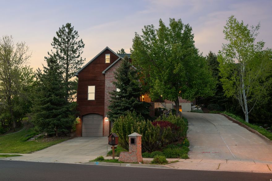 Tucked into a private, tree-filled setting, this Layton home offers the feel of a true mountain retreat without leaving the convenience of the city. Surrounded by mature trees on a .41-acre lot, the setting is peaceful, secluded, and hard to find. The standout feature is the stunning family room with vaulted ceilings, faux wood beams, and windows on three sides bringing the outdoors in and filling the space with natural light. Step out onto the spacious back deck, perfect for entertaining or simply enjoying the quiet surroundings. With 3,594 sq ft, multiple living areas, and a functional layout, there's room to spread out while still feeling connected. The huge main-level primary suite adds convenience, while additional bedrooms and flexible spaces allow for guests, office, or hobbies. A 4-car garage (2 on upper level and 2 on lower level) provide space for all your needs.  If you've been looking for privacy, views, and a home that feels like an escape, this is it. Opportunities like this don't come up often, schedule your showing before it's gone!