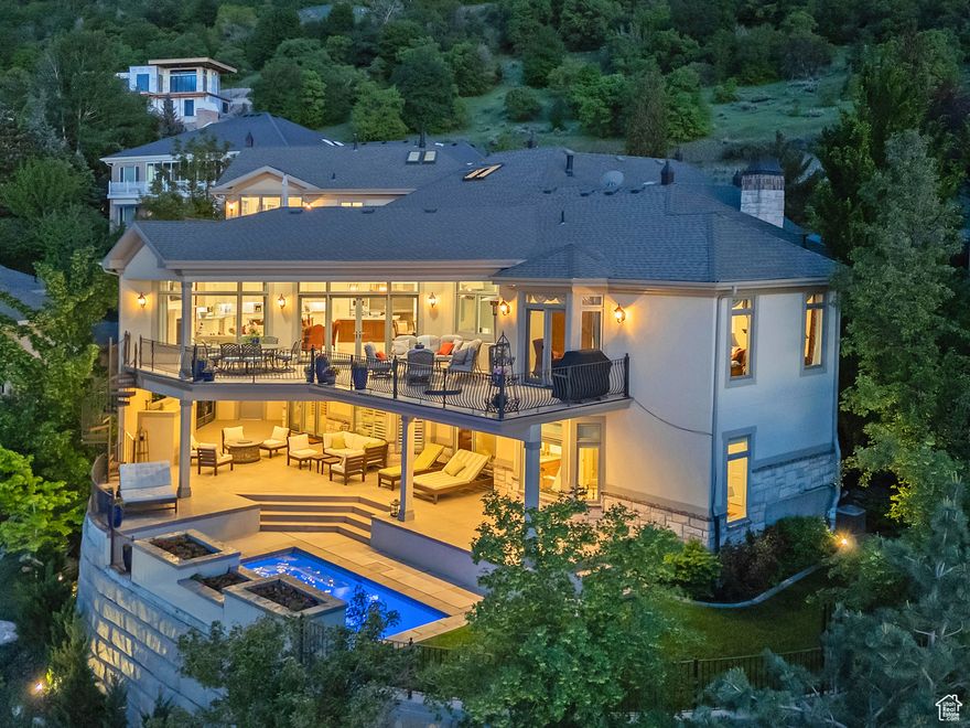 Experience the ultimate million-dollar panoramic views of the Salt Lake Valley and dramatic cliffs and colors of Little Cottonwood Canyon.  Beautifully reimagined architecture brings exceptional quality craftsmanship, refined details and stunning features (the primary suite closet is to die for). Enter through the vaulted marble foyer into a grand great room anchored by a chef's dream kitchen-featuring top of the line appliances and dual oversized islands and expansive pantry, open dining room and exquisite temp-controlled and illuminated wine room, custom wood surround office and a main floor primary suite- all masterfully designed to keep the breathtaking views the centerpiece.  An elegant, curved staircase ascends to a spectacular upper-level second primary retreat, complete with a spa-inspired bath featuring a custom round tub and a walk-in closet to rival all. The lower level is bright and spacious, offering a secondary great room, full kitchen, exercise studio, theater, laundry, three bedrooms, and two bathrooms-all with direct walkout access to a covered patio and a private saltwater pool with outdoor shower. Lutron Programmable Lighting (Connects through phone). Two private decks extend the living space outdoors, a four-car garage, and a heated driveway elevate everyday convenience. Framed by a tranquil waterfall and serene stream.  One of Salt Lake's most exclusive estates, this home combines privacy and prestige with unmatched proximity to world-class ski resorts, premier medical centers, fine dining, shopping, and entertainment. *Square Footage is provided as a courtesy only. Buyer is advised to obtain an independent measurement and verify all information.*