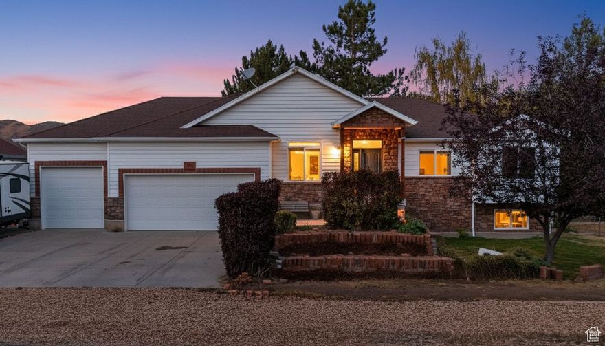 Your Country Escape Awaits in Henefer, Utah!  Discover the peaceful country living you've been dreaming of in this beautiful Henefer home, surrounded by sweeping mountain views and serene horse pastures. Just off Interstate 84, you'll enjoy easy access to five nearby reservoirs and the Weber River-perfect for fishing, paddleboarding, or simply soaking up nature. Plus, Utah's world-class ski resorts like Deer Valley, Park City and Snowbasin are just 40 minutes or less away! This spacious 5-bedroom, 2.5-bath home is move-in ready with fresh paint and new carpet throughout. The kitchen is a chef's delight, featuring a gas stove and cooktop, granite countertops, and an extra-height island ideal for entertaining. The open-concept living room offers a cozy gas fireplace, perfect for relaxing evenings. On the main floor, you'll find an office with a tranquil water feature, three bedrooms including a vaulted master suite with a walk-in closet, and a convenient laundry room with direct access to the three-car garage. The finished basement adds even more living space with a large family room featuring a built-in TV cabinet, two additional bedrooms, a brand-new full bathroom, and a walkout to the backyard. Step outside to enjoy a spacious .28-acre lot with a 30-foot concrete pad for trailer parking, a large deck and patio-perfect for gatherings or peaceful mornings with a view. Don't miss your chance to own this slice of country paradise! (Square footage figures are provided as a courtesy estimate only and were obtained from county records. Buyer is advised to obtain an independent measurement.)