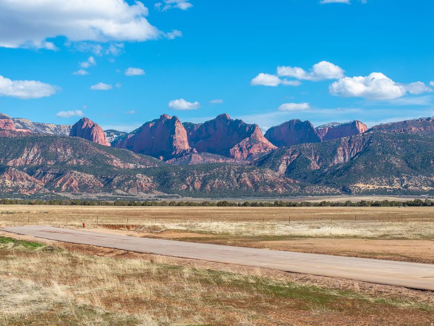 Discover wide-open space and unforgettable views with this 5.63-acre corner lot in beautiful New Harmony. Surrounded by stunning panoramic mountain and red rock cliff views, this flat, buildable parcel offers paved road access and power nearby, making it an ideal location for your custom home. It is also part of the Washington Conservancy Water District. Enjoy peaceful rural living with plenty of room for a home, shop, animals, or outdoor recreation. Located in a quiet area with established homes nearby, the property offers breathtaking scenery in every direction. Conveniently situated between Cedar City and St. George, this property combines privacy, space, and incredible Southern Utah landscapes in one exceptional opportunity.