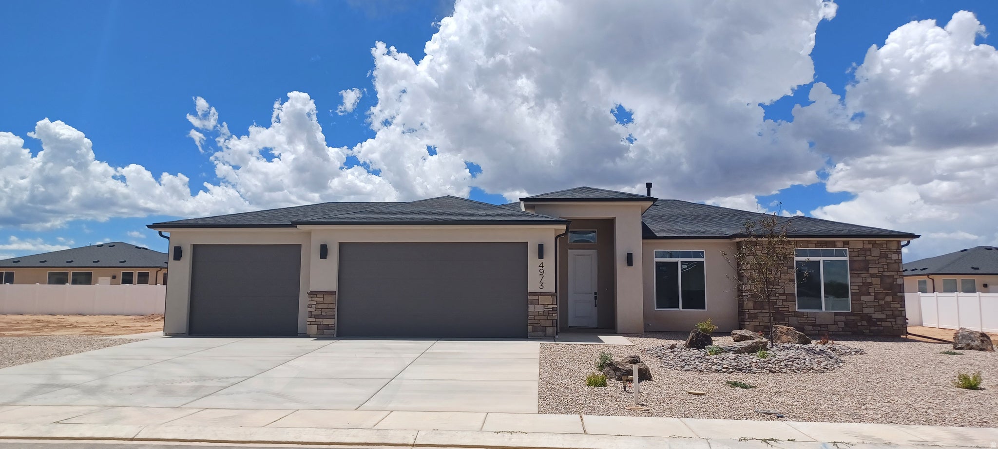 Contemporary single-story residence featuring a stucco exterior with stone accents