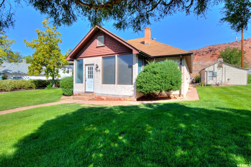 CHARMING OLD TOWN HOME WITH RENTALS - Now offering Seller Financing! This residential property is situated on a sprawling 2.03-acre lot and features the  vintage main house with 3 bedrooms, 1 full bath and 2 3/4 bathrooms, a cozy 640 square foot cottage with 1 bedroom and 1 bathroom, a manufactured home with 3 bedrooms and 2 bathrooms, and a huge 30x60 Quonset hut perfect for a workshop or storing all of your Moab outdoor toys. The main house celebrates plenty of natural light and ample living space, perfect for entertaining guests or spending quality time with loved ones. The cottage is a perfect guest house or rental property, and the manufactured home offers plenty of room for more guests or additional rental income. The property also includes outdoor space, perfect for enjoying the beautiful natural surroundings of vermillion rolling hills and views of the Moab Rim. With its convenient location just two blocks from Main Street, in Moab's Old Town Blocks, and a variety of living options, this property is a must-see! Don't miss the opportunity to own this unique and versatile property.