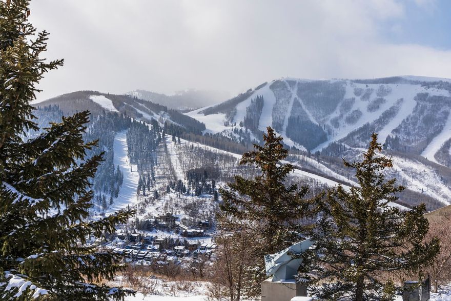 Perched high above historic Park City, this extraordinary ridgeline estate captures some of the most breathtaking panoramic views in Park City - from the world-class slopes of Deer Valley to the iconic mountains of Park City Mountain to the front and acres of serene aspen forest and protected open space to the back.  Just two minutes from the heart of Old Town, this rare .57-acre property is one of the very few homes positioned directly on the ridgeline above town, offering unmatched privacy with coveted cul-de-sac living and immediate access to Park City's abundant trail system.  Spanning 5,847 square feet, the thoughtfully designed six-bedroom, five-bath residence features an intelligent floor plan that balances grandeur with warmth. Soaring two-story windows flood the home with natural light, while a dramatic double-sided stone fireplace anchors the open-concept living spaces. The chef's kitchen flows seamlessly into fireside dining - perfect for gathering and entertaining against a backdrop of unforgettable views.  The massive primary suite is a private retreat, complete with its own sitting room, fireplace, jetted tub, steam shower, expansive walk-in closet room, and an oversized terrace perfectly oriented to capture sweeping mountain vistas. A second primary suite offers a walk-in closet, soaker tub, forest views, and private terrace access.  Four additional bedrooms are thoughtfully situated across the main and lower levels. The lower level is designed for recreation and relaxation, featuring a theater room, gaming area, bar. A spa room with access to the grand forest terrace is also on the list.. An oversized three-car garage, along with unfinished wine and storage spaces, provides ample room for all your mountain lifestyle essentials.  A rare opportunity to own one of Park City's most enviable view properties - where alpine beauty, privacy, and proximity to town converge seamlessly.
