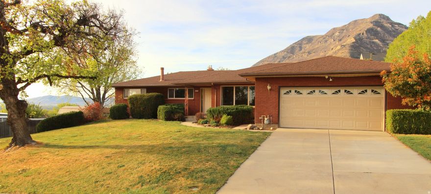 Welcome to this all brick, rambler style home in beautiful East Pleasant Grove. Traditional design elements are featured like a spacious family room with wood burning stove, a living room, dining area, nook and bar. Large windows allow daylight and the East bench views you'd expect. There are 4 bedrooms, three baths, and room to grow with a 5th nonconforming room in the basement that could be converted. Also in the basement you'll find another large family room, separate entrance/walk out access, and hundreds of square feet of storage/finish potential. A .369 ac lot allows mature trees, ample rear yard, storge shed, garden area, and a covered patio with outdoor fireplace, perfect for entertaining.