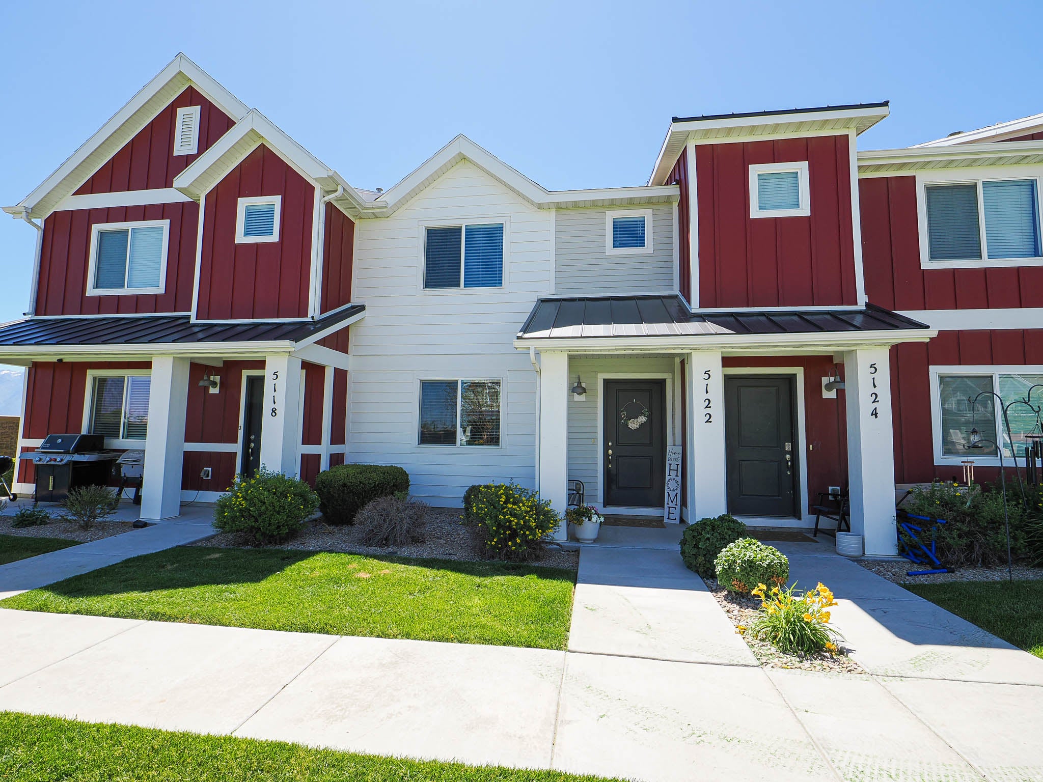 Modern townhome exterior featuring red board and batten siding with white trim