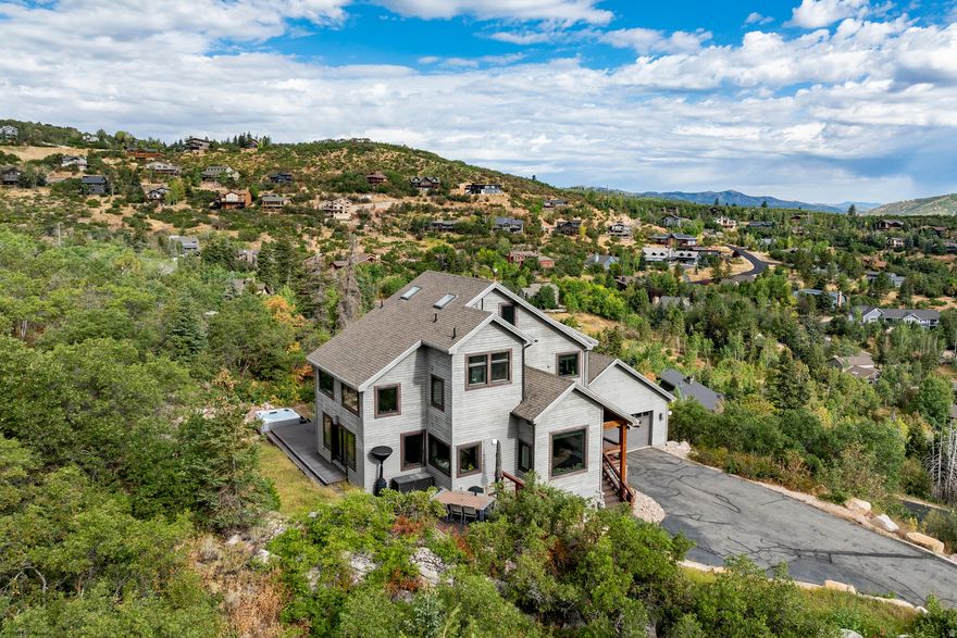 Nestled on the sought-after Pinebrook hillside, this tastefully remodeled home offers unmatched privacy, panoramic views, and a rare sense of space with two combined lots totaling 1.26 acres. Ideally situated just minutes from Park City's world-class ski resorts, 5 minutes from Woodward Park City, and 20 minutes from Salt Lake City, it's the perfect mountain retreat with urban convenience. The home has been fully renovated in a sleek contemporary style, featuring a new gourmet kitchen with custom cabinetry, Thermador induction cooktop, quartz countertops, and stainless steel appliances. All bathrooms, flooring, windows, and HVAC have been updated with high-quality finishes throughout. The open main level includes a spacious living room with 180-degree views and a linear fireplace, a formal dining area that seats 12, and a breakfast nook with stunning mountain vistas. Upstairs are two primary suites with en-suite baths and breathtaking views, along with a generous office. The lower level includes a spacious living area that would make a greatmother in law suite with bathroom and separate entrance along with an additional en-suite bedroom. Three outdoor decks capture the dramatic landscape, surrounded by striking rock formations and natural beauty. Additional upgrades include a hot tub, updated landscaping, gutters, and heat tape. Furniture is negotiable. Enjoy the outdoors with the extensive Pinebrook private hiking and biking trails along with accommunity pickle ballcourt, tennis courts, and parks. With a motivated seller, this exceptional property represents a rare opportunity in one of Park City's most desirable neighborhoods.