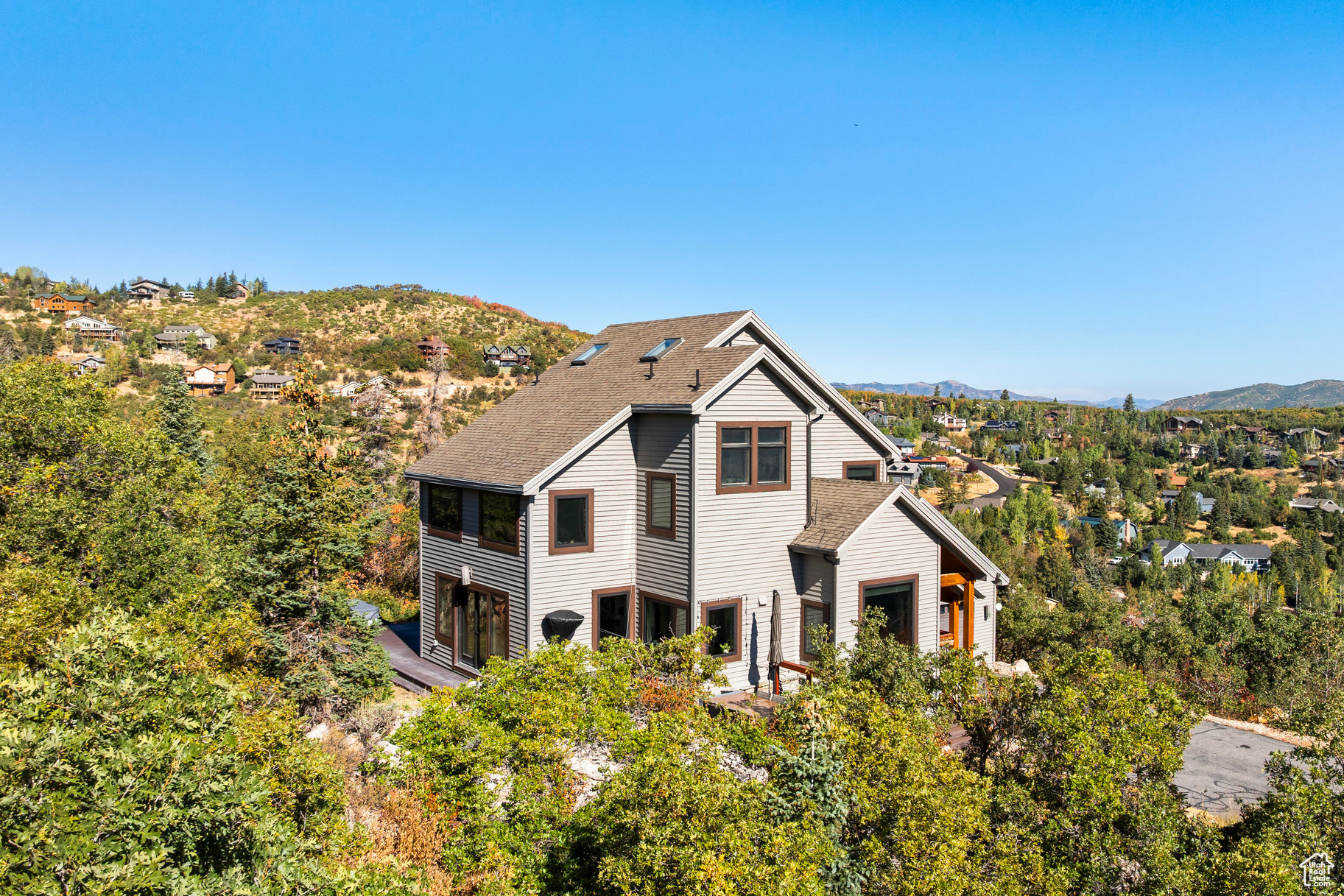 Nestled on the sought-after Pinebrook hillside, this tastefully remodeled home offers unmatched privacy, panoramic views, and a rare sense of space with two combined lots totaling 1.26 acres. Ideally situated just minutes from Park City's world-class ski resorts, 5 minutes from Woodward Park City, and 20 minutes from Salt Lake City, it's the perfect mountain retreat with urban convenience. The home has been fully renovated in a sleek contemporary style, featuring a new gourmet kitchen with custom cabinetry, Thermador induction cooktop, quartz countertops, and stainless steel appliances. All bathrooms, flooring, windows, and HVAC have been updated with high-quality finishes throughout. The open main level includes a spacious living room with 180-degree views and a linear fireplace, a formal dining area that seats 12, and a breakfast nook with stunning mountain vistas. Upstairs are two primary suites with en-suite baths and breathtaking views, along with a generous office. The lower level includes two additional en-suite bedrooms, equally refined. Three outdoor decks capture the dramatic landscape, surrounded by striking rock formations and natural beauty. Additional upgrades include a hot tub, updated landscaping, gutters, and heat tape. Furniture is negotiable. Enjoy the outdoors with the extensive Pinebrook private hiking and biking trails along with the community pickle ball, tennis courts, and parks. With a motivated seller, this exceptional property represents a rare opportunity in one of Park City's most desirable neighborhoods.