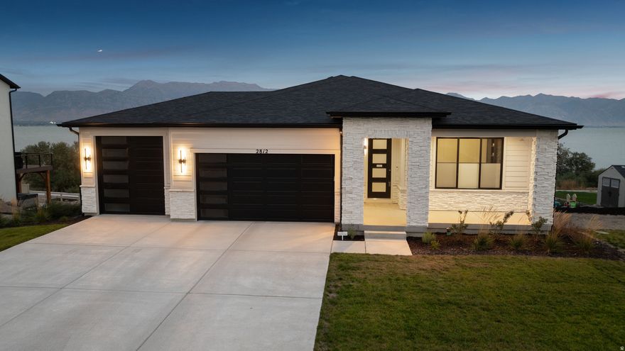 RARE UTAH LAKEFRONT LUXURY. Thoughtfully designed as a high-end rambler, this home delivers elegant main-level living with comfort, accessibility, and timeless style. Extensive custom upgrades throughout reflect a no-expense-spared approach to quality.  Outdoor living is extraordinary. Expansive, professionally designed decks frame unobstructed lake and mountain views with no backyard neighbors. A modern spiral staircase connects multiple spaces for entertaining or relaxing, while the backyard offers a rare blank canvas for a custom outdoor sanctuary-ideal for refined landscaping or outdoor entertaining.  Interior highlights include Cafe white appliances, custom office cabinetry, a basement kitchenette, two fireplaces, and custom built-ins, and striking inside-out black windows that create a clean, modern aesthetic. The primary suite showcases stunning lake and mountain views, a spa-inspired bath with a separate tub and shower, and a fully customized walk-in closet. Additional features include modern top-down, bottom-up window coverings, premium water softening and filtered drinking water systems on both floors, a finished garage with epoxy flooring and EV-charging, and exterior conveniences such as an outdoor BBQ gas line and hot tub outlet.  Move in now and enjoy lakefront living from day one. Opportunities like this are limited, making it an exceptional option for buyers seeking a true waterfront lifestyle. A fully furnished option is available at the right price, and special mortgage savings may be offered to qualified buyers. No Showings without an appointment.