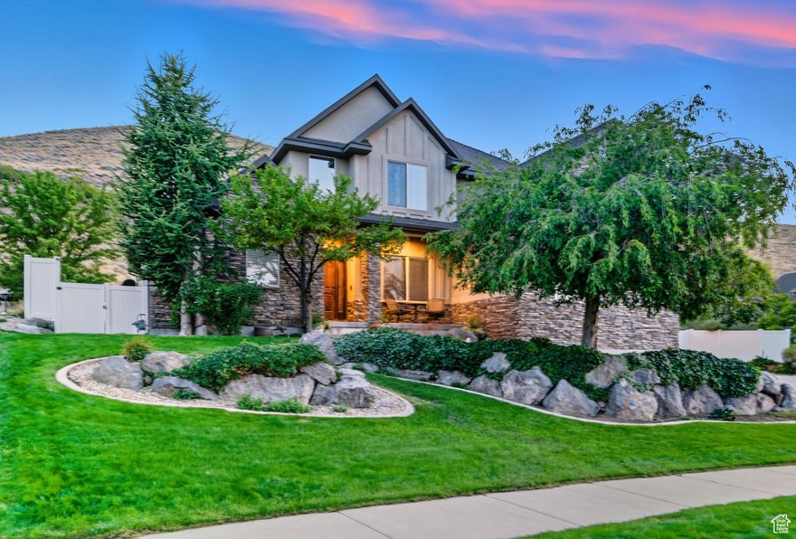 Welcome to one of Herriman's most sought-after locations, perfectly positioned on a premier lot that backs the mountain for ultimate privacy and breathtaking views. The beautifully landscaped yard is a true retreat, complete with a covered patio and RV parking. Inside, the home has been thoughtfully updated with fresh paint, designer lighting, stainless steel appliances, and high-end quartz countertops. The spacious layout includes a luxurious main-level owner's suite featuring a spa-inspired bathroom and expansive walk-in closet, along with a custom entertainment center that anchors the living space beautifully.  The fully finished walkout basement is an entertainer's dream, showcasing a custom built-in entertainment center and a stylish bar area with plumbing already stubbed for a full kitchen conversion if desired. Outdoors, enjoy direct access to nature with hiking and biking trails just steps away, and take a short walk to Blackridge Reservoir. With excellent schools nearby and endless shopping, dining, and entertainment options minutes away, this home offers the perfect balance of tranquility and convenience. A rare find on an exceptional lot this is a true Herriman gem.