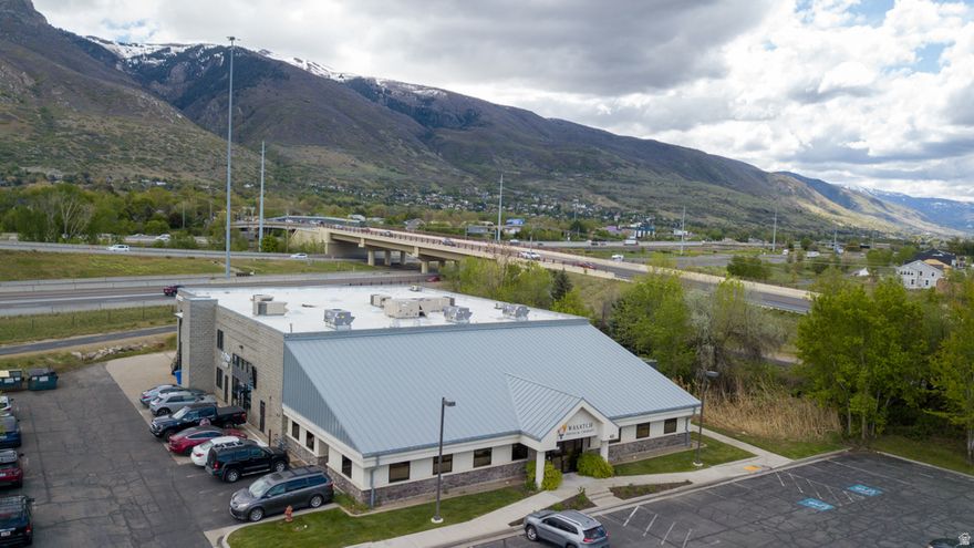 Located in the heart of Farmington, Utah, this modern and recently renovated commercial property offers an exceptional opportunity for businesses seeking a premium office space in a prime location. The property is within walking distance of Station Park, one of Utah's premier retail and dining destinations, and the Frontrunner train station, providing seamless access to major transit hubs and regional connectivity. It's also conveniently situated near walking and bike trails, creating an ideal work environment that balances productivity with lifestyle amenities. This 1.314-acre property, built in 2010, features a rentable space of 17,456 square feet. Designed with contemporary businesses in mind, the interior includes 16 private offices, 4 conference rooms, 5 break-out offices, 6 large workspaces, and 2 break rooms, all complemented by an open-concept industrial design. The building offers stunning mountain views and direct proximity to the Farmington Creek greenbelt, providing an inspiring work atmosphere. The building is classified as Class B and constructed with durable masonry materials, ensuring quality and longevity. Additionally, the property includes ample parking with 76+ stalls and a building-to-land ratio of 30%. Technology companies and modern businesses will appreciate the robust infrastructure, featuring high-speed fiber up to 10 Gbps/10 Gbps, ensuring uninterrupted connectivity. Security is a top priority, with secured access via door fobs and advanced building automation systems in place to enhance convenience, safety and efficiency. Strategically positioned for maximum exposure, the property boasts approximately 180 feet of frontage on Phoenix Way, 325 feet on State Street, and 240 feet on Legacy Parkway. The high traffic counts in the area, with an estimated 188,500 annual average daily traffic (AADT), make this an excellent choice for businesses seeking visibility and accessibility. The surrounding area is rich in amenities, with over 45 restaurants, two hotels, and two grocery stores located nearby. Employees will enjoy walking distance access to Station Park's dining and retail options, as well as nearby public transportation, including bus stops and the FrontRunner train station. The property also provides direct access to multiple walking and biking trails, enhancing its appeal to businesses that prioritize employee wellness. Accessibility is another key advantage of this property. It is conveniently connected to major highways, including I-15, Legacy Parkway (UT-67), Hwy-89, and the West Davis Corridor (UT-177). Salt Lake City International Airport and Downtown Salt Lake City are just 20 minutes away, and Ogden is only a 25-minute drive. The proximity to the new North Farmington Station development, a 317-acre mixed-use project, further enhances the property's appeal as an investment in a rapidly growing area. This property is zoned TMU (Transit Mixed Use), allowing for diverse applications, including office, retail, and multi-family use, making it a versatile choice for investors or business owners. Its modern amenities, strategic location, and adaptable zoning make it ideal for corporate headquarters, co-working spaces, or mixed-use developments. Don't miss this opportunity to secure a high-quality, well-connected commercial property in one of Utah's most dynamic areas. Contact us today to schedule a private tour and discover the full potential of this exceptional listing.