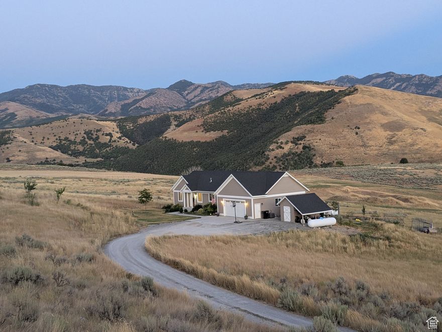 STUNNING Home with Breathtaking Mountain and Valley Views! This 2017 home in Cub River Ranches offers style, comfort, and privacy. You'll love the panoramic views from this secluded 5.7-acre sanctuary. The gourmet kitchen features stainless appliances, custom cabinetry, granite countertops, large island and a walk-in pantry. Main-floor living includes the primary suite with custom shower and freestanding soaking tub. This home offers 5 bedrooms, 2 family rooms, 2 baths, vaulted ceilings, gas fireplace and custom hardwood floors throughout. Entertain in style on over 500 square feet of covered deck and patio while soaking in the incredible vistas. The oversized garage includes a built-in shop, plus there's a detached tool shed and attached greenhouse for gardening enthusiasts. The landscaped yard features natural rock retaining walls, sprinkler system, mature trees, orchard and plenty of space for outdoor activities. Located in Cub River Ranches subdivision with low HOAs ($40/month) and great neighbors. Positioned off the main road on a private 3-mile loop with no homes on adjacent lots-just common space and farmland for complete privacy. Existing fencing makes this perfect for horses, pets and farm animals. Enjoy country living with easy access to canyon and reservoir recreation, yet just 25 minutes to Logan. Don't miss this opportunity! Owner-Managed Showings: Contact Natalie at 435-770-1462 to schedule showings. For offers and contract questions, contact listing agent Tammy Jensen at 435-754-7166 and email offers to tammy.jensen@exprealty.com Serious inquiries only. Buyer to verify all information, including square footage and acreage. Home is occupied-please provide reasonable notice for showings.