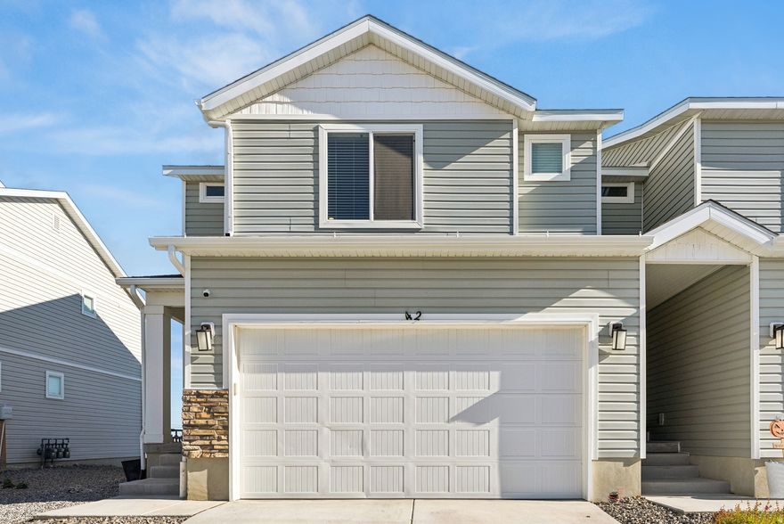 This move in ready 3-bedroom, 2-bath end unit townhome lives like new. The bright and airy open-concept kitchen and living room. Natural light fills the living space with two additional windows along the unshared wall. Plenty of storage space can be found throughout the home, from the kitchen pantry, large closets on the main floor, to the upstairs bedrooms, basement and 2 car garage. The spacious primary suite with 2 walk in closets and en-suite will become your favorite retreat. The Laundry is conveniently located on the same level as the bedrooms complete with shelf to store all your laundry day essentials. An unfinished basement provides room to grow, already roughed in to add a full bathroom. Step outside onto the large deck for sipping your favorite beverage or enjoying a BBQ in the fresh air. Low-maintenance living in a family- and dog-friendly community featuring a playground and picnic area. Located just minutes from outdoor recreation, with spectacular mountain views and peaceful surroundings. Ideal for those who work remote. Just a quick 35 minute drive to downtown SLC or the Airport.