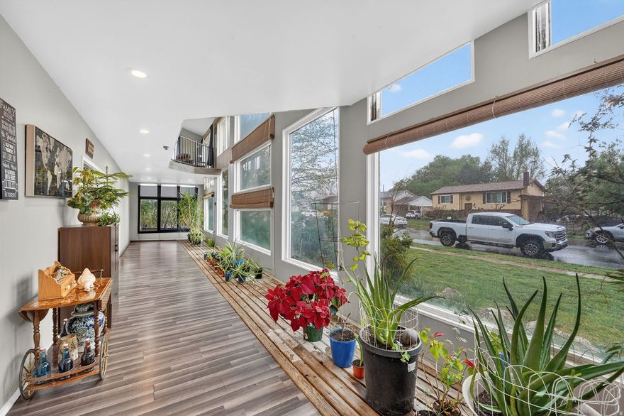 Welcome to a truly one-of-a-kind home that stands out from everything else in the neighborhood! This spacious 6-bedroom, 3 bathroom home sits on a nearly half-acre lot and offers a rare combination of charm, space, and character you won't find in a typical property. From the moment you arrive, you'll be drawn in by the stunning two-story atrium at the front of the home. This incredible feature brings in an abundance of natural light and creates a unique indoor-outdoor feel, blending the beauty of a garden space with the comfort of home. It's a true showstopper that sets this property apart. Inside, the open-concept main floor is designed for both everyday living and entertaining. The remodeled kitchen flows seamlessly into a large family room, creating the perfect gathering space for friends and family. Whether you're hosting or just enjoying a quiet night in, this layout offers flexibility and comfort. Upstairs, all bedrooms are thoughtfully located for privacy and convenience. You'll also find a charming loft space overlooking the atrium below-ideal for a playroom, reading nook, or home office. Step outside to your expansive backyard, where you'll find a peaceful pond and a beautiful mature tree that provides plenty of shade during the summer months. With nearly half an acre, there's room to relax, garden, or customize the space to fit your vision. Complete with a 2-car garage that comes with a 6ft service pit. A truly unique design, this home offers endless possibilities.  Homes like this are incredibly rare-schedule your private tour today before someone else falls in love with it first!