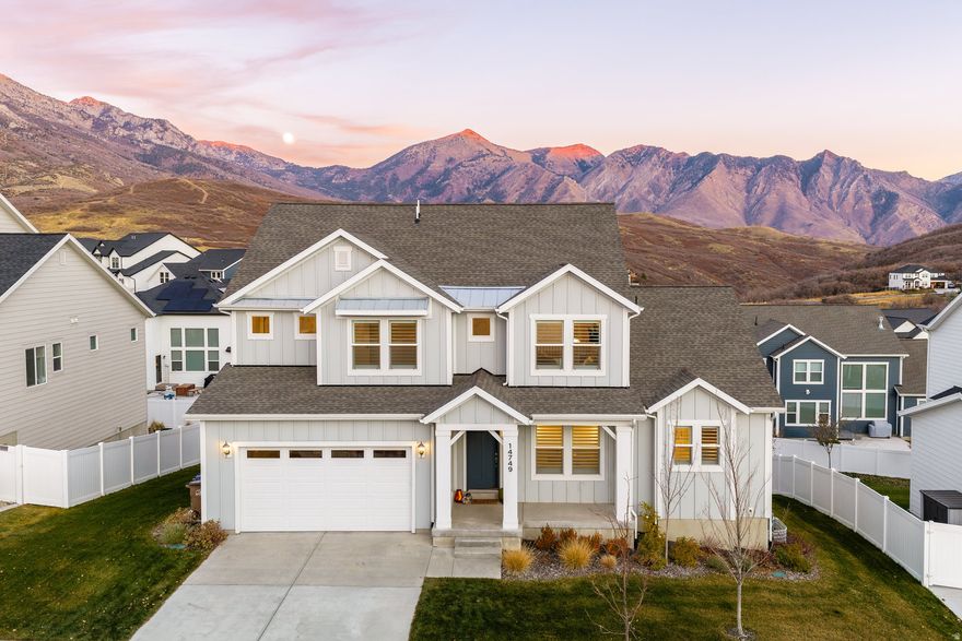 Imagine cuddling up with the moonlight spilling over Lone Peak, right outside your primary bedroom doors. From the moment you step onto your private balcony, it's clear this home was designed to capture both the beauty and serenity of Suncrest living. This sought-after Tessa floorplan offers a spacious main-level primary suite with a walkout balcony-making every morning feel like a mountain retreat. The ensuite features a large walk-in closet, double vanity, and standalone tub offering comfort and convenience in a beautifully balanced layout.  At the heart of the home, a gourmet kitchen awaits with double ovens, a generous island, and a walk-in pantry perfect for both quiet mornings and lively gatherings. Natural light pours through every corner, creating a warm and inviting flow between the dining, living, and outdoor spaces.  Upstairs, a bright and airy loft anchors three additional bedrooms, giving everyone their own space while still feeling connected to the main floor activity. Downstairs, the unfinished walkout basement with above-grade windows is brimming with potential, ideal for future expansion or even a separate unit.  Outside, the large, flat yard is finished with high-quality turf, offering a low-maintenance lifestyle and the perfect spot for kids, pets, or evening relaxation under Suncrest's starry skies.  Nestled in one of the most scenic and outdoor-centric communities along the Wasatch Front, this home blends thoughtful design, comfort, and everyday luxury where every moonrise feels like an invitation to stay a little longer. This house has an assumable VA loan with 2.375% interest rate - please inquire if interested.