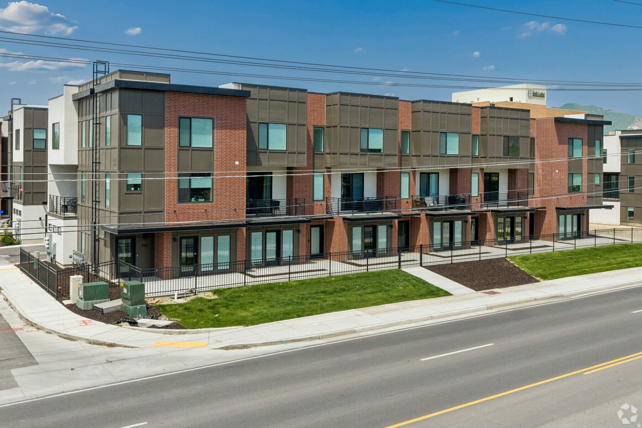 Modern multi-story building featuring brick and panel exterior finishes