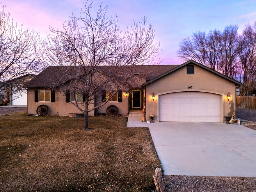 This charming 4-bedroom, 2-bathroom home at 167 E 600 N in Roosevelt, Utah, perfectly blends comfortable modern living with authentic Western flair, making it an ideal retreat in the heart of the Uintah Basin. Step up to the inviting exterior, where the classic tan stucco facade is proudly adorned with striking Western decor-including impressive rustic log accents, a wooden bench, and natural tree-trunk posts that give it that true cowboy-country charm. The 28 X 40 detached garage has room for vehicles, toys, or farm equipment, while the surrounding yard and fencing hint at the rural lifestyle Roosevelt is known for. Inside, the open and airy layout shines in the gorgeous kitchen, featuring warm honey-toned wooden cabinetry, a large corner setup with ample counter space (including a sleek stainless steel sink and modern appliances), and a bright, welcoming atmosphere. Vaulted ceilings and large windows flood the space with natural light, seamlessly connecting the kitchen to the adjoining living and dining areas-perfect for family gatherings or casual entertaining. The home offers four generously sized bedrooms and two full baths, providing plenty of space for family, guests, or a home office. The thoughtful floor plan includes cozy carpeted living spaces and practical touches throughout. From the aerial views, you'll appreciate the property's convenient location on half acre lot, with room to roam, potential for outdoor activities, and easy access to Roosevelt's amenities, schools, shopping, and the stunning natural surroundings of eastern Utah-think nearby mountains, recreation, and that peaceful small-town vibe. Whether you're drawn to the authentic Western-themed exterior that screams "Utah ranch style" or the functional, light-filled interior ready for your personal touch, this property captures the spirit of the West while offering everyday comfort.