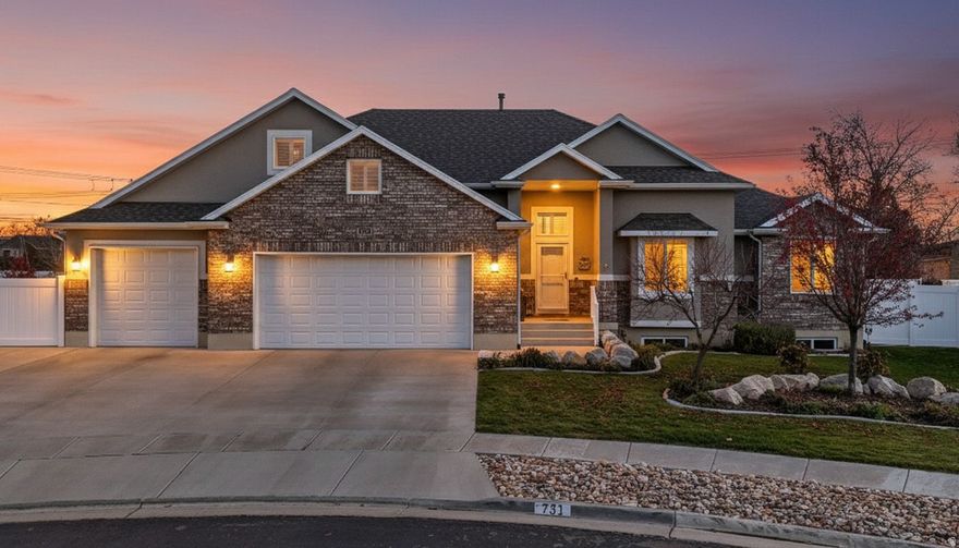 Celebrate at one of Castle Creek's finest custom-built Alexander floor plans established conveniently near West Davis Corridor and Highway 193 for quick access to amenities all across the Salt Lake Valley. And then, as you return, you can find yourself within walking distance of a beautiful temple, a future Costco, and are embraced by the suburban beauty that characterizes Syracuse living. This rambler residence with nearly 4,000 Sq. Ft. was built in 2017 on a manicured third of an acre lot and includes a 4-car garage, RV parking, garden space, outdoor fire pit, covered patio space and has been fortified through the installation of a Generac home generator, sump pump, and dehumidifier to preserve the luxurious woodwork throughout. Accept your invitation inside and you will be welcomed by American Rustics hardwood flooring with a 50-year finish warranty, vaulted ceilings that overarch the main floor living space and lead to the kitchen's luxurious wooden cabinetry, granite countertops, stainless steel appliances including a gas stove, built-in range hood for exterior ventilation, and a spacious walk-in pantry. One of the main themes of this home is space, and that is emphasized further as you make your way to the owner's suite consisting of bay windows, a double-vanity, a roman walk-in shower paired with a garden tub and is completed with an oversized walk-in closet. As you then explore the rest of this home you will discover a bonus room loft, a finished basement with a kitchenette, and two oversized cold storage areas. These features help conclude that at 731 S 3050 W there is indeed more than enough space for you to celebrate this reality. Buyer to verify all information.