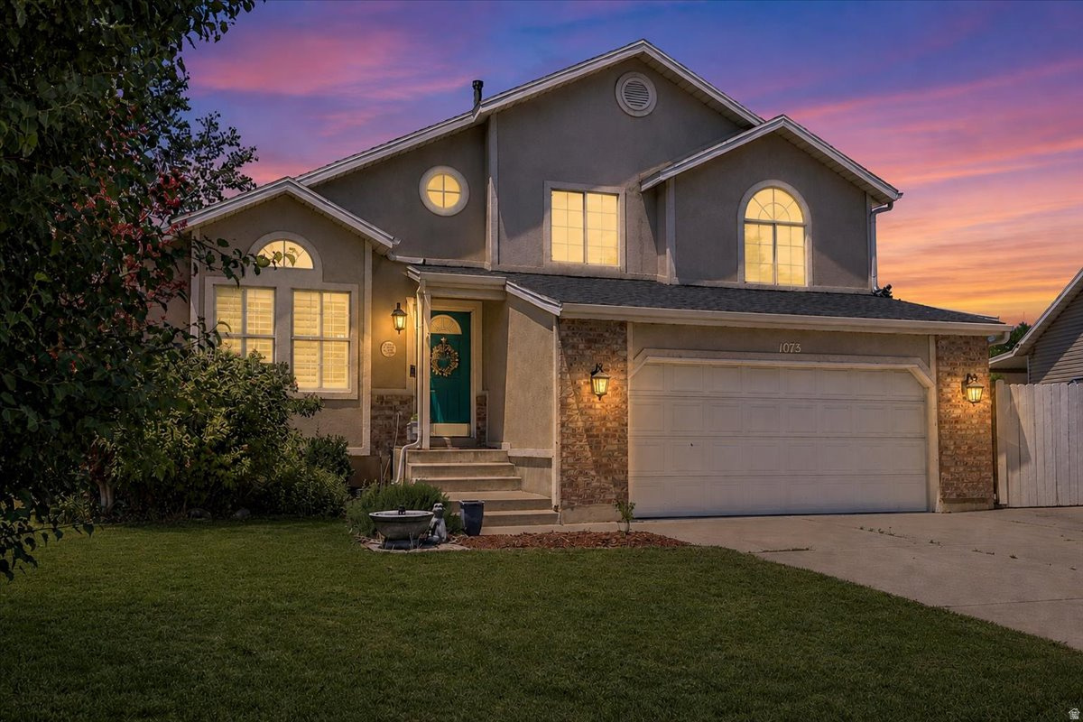 Stucco exterior featuring stone accents and arched windows