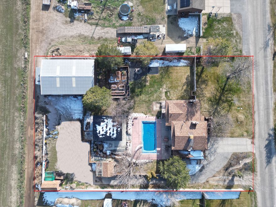 Now Priced at $985,000. Detached studio home (896 sq ft) with immediate income of approximately $1,800/month, ideal for offsetting the mortgage, multigenerational living, or guests, sets this property apart. The detached studio also features a ductless mini-split system for efficient, individual climate control. Situated on a private .93-acre lot at the end of a quiet dead-end road, the property includes a heated 3060 shop with office space, offering exceptional flexibility for vehicles, hobbies, or business use, plus ample additional parking.  The main residence offers 3,100 sq ft, 4 bedrooms, and 4 bathrooms in a versatile multi-level layout with new interior paint and new carpet in the basement family room, along with a newly added three-quarter bathroom. The main home is also equipped with a ductless mini-split heating and cooling system, providing individual room climate control.  Outdoors, enjoy a resort-style backyard with pool, pond, and mature landscaping, creating a private setting ideal for entertaining or relaxing.  A rare opportunity combining income potential, acreage, functional space, and lifestyle - a truly unique offering.