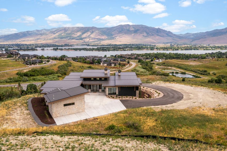 At the end of each day, retreat to your brand new 5,392 sq. ft. contemporary mountain estate set on 4.22 acres with panoramic views of the mountains and Pineview Reservoir. This custom 4 bedroom 5 bathroom home offers refined living with high end finishes and thoughtful detail throughout. Begin your mornings with sweeping sunrises from your private decks or the comfort of your Owner's Suite. This property delivers a rare lifestyle in the heart of Ogden Valley. Legacy Mountain Estates is a premier luxury community where adventure and calm come together. Enjoy year round recreation with quick access to Pineview Reservoir and its beaches and boat ramps. Outdoor enthusiasts can explore private access to scenic hiking and mountain biking trails weaving through forests and open meadows. In winter, reach Powder Mountain or Snowbasin Resort in 15 to 25 minutes for some of the best skiing in the West. In warmer months, use your complimentary one year membership to Wolf Creek Resort and enjoy 18 holes of golf with impressive mountain and lake views. Square footage figures are provided as a courtesy estimate only and buyers are advised to obtain an independent measurement.